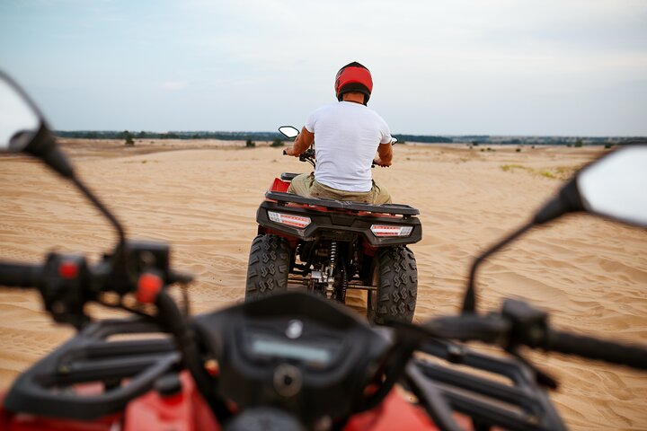 Experience the excitement of navigating the stunning desert terrain on an ATV perfect for first-time riders eager to develop their skills in a breathtaking landscape.